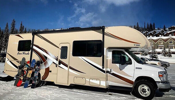 Snowboards leaning on a Class C motorhome in a ski resort
